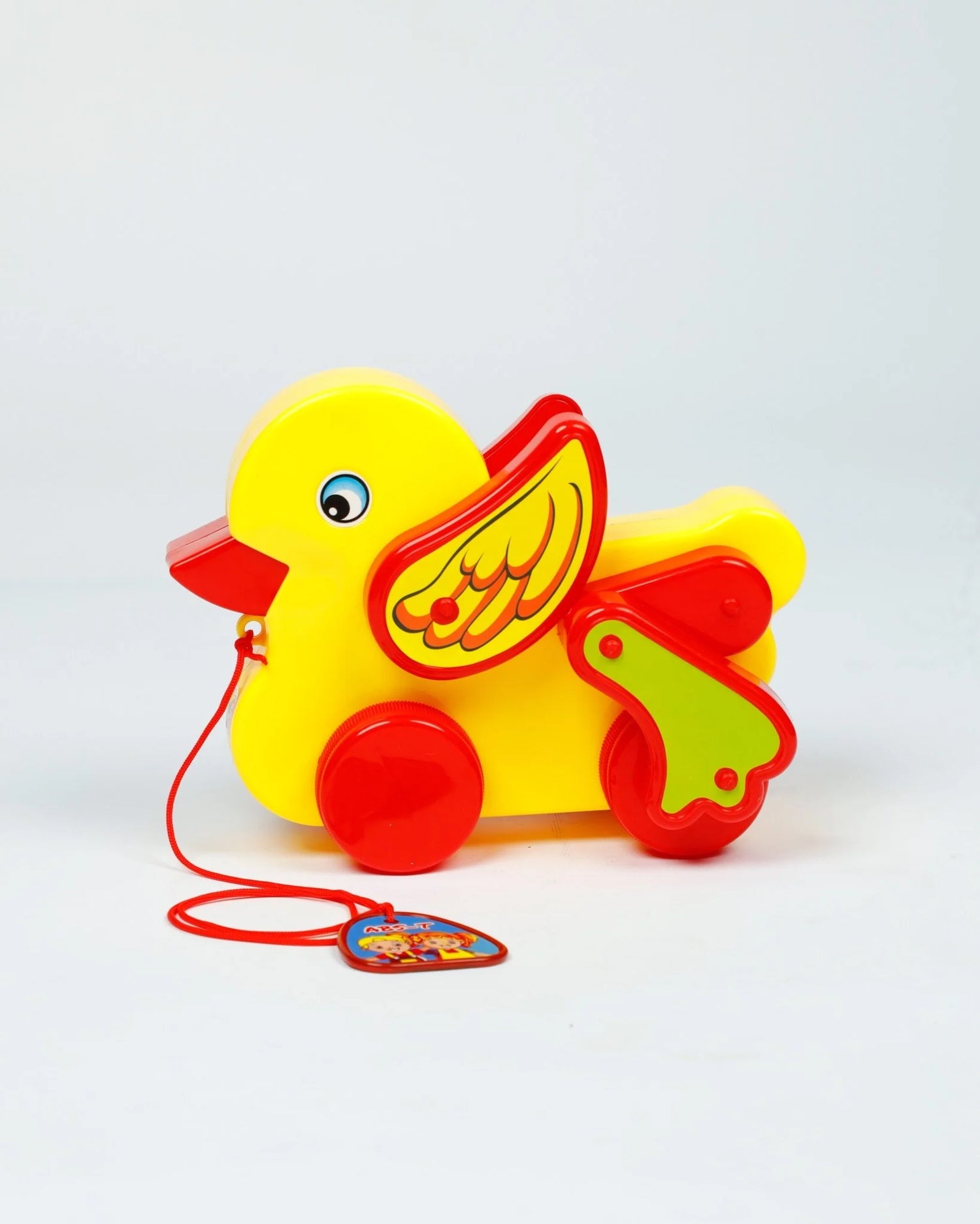 Yellow duck toy with red wings and a pull string on a white background