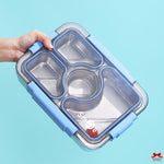 Stainless steel lunch box with compartments held by a hand against a light blue background
