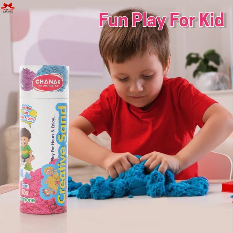 Child playing with blue creative sand next to a box labeled 'Chanak Creative Sand' on a light-colored surface.