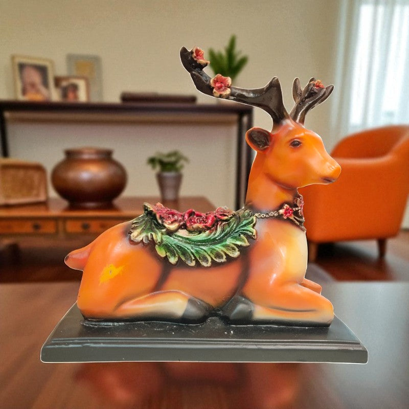 Decorative figurine of a deer with floral antlers on a table in a room.