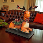Decorative reindeer figurine with flowers on a table in a living room.