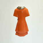 Orange dress with metallic collar on a white background