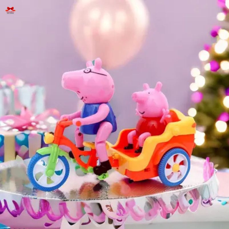 Two cartoon pig figures on a toy bike and cart with balloons and a Christmas tree in the background.