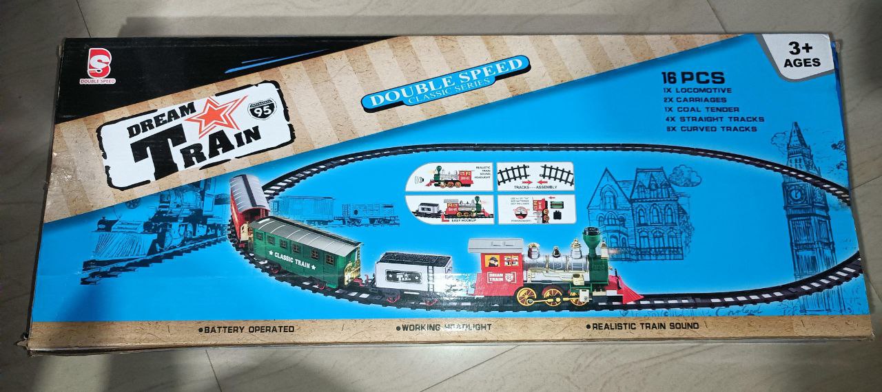 Dream Train toy set packaging with train tracks and cars on a blue background