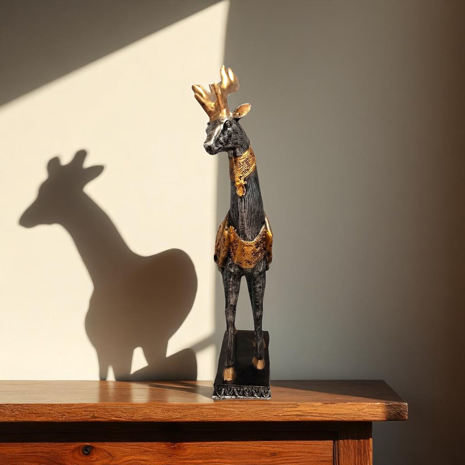 Front view of golden deer showpiece casting elegant shadow on wall.