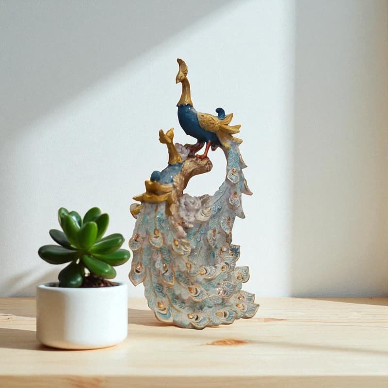 Decorative peacock sculpture with a small potted plant on a wooden surface