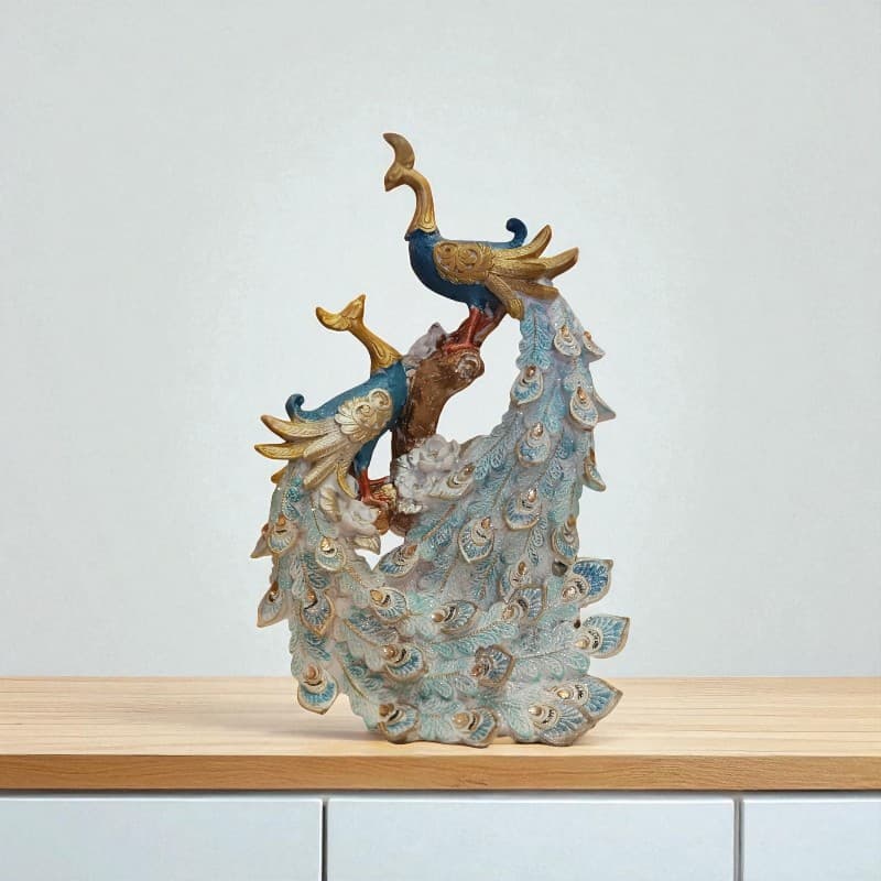 Decorative peacock sculpture on a wooden surface with a light gray background