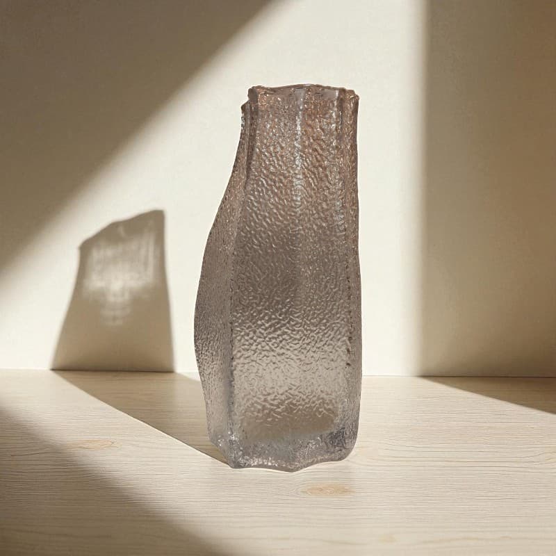 Textured glass vase on a wooden surface with soft lighting