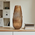 Brown textured vase on a wooden surface with a blurred background