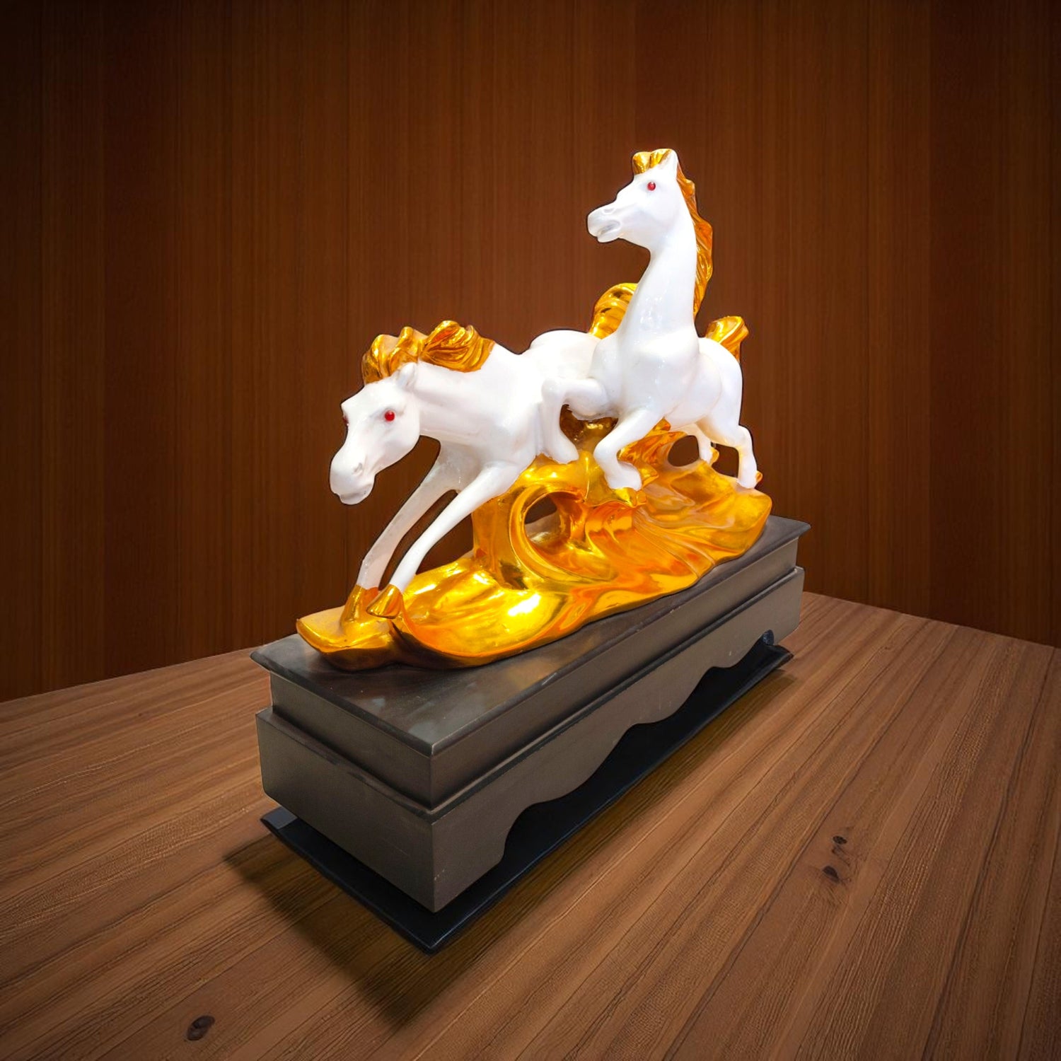 Side profile of running horses statue with golden base