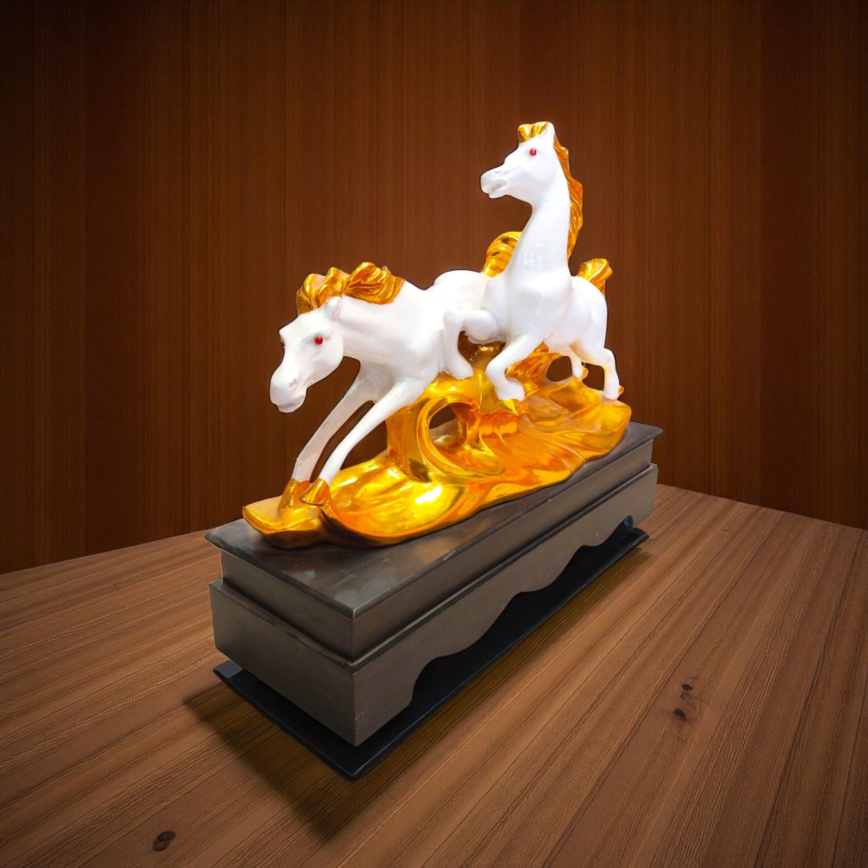 Side profile of running horses statue with golden base