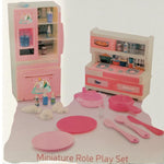 Close-up photo of Unicorn Kitchen Set accessories including pink plates, pans, spoons, fridge, and stove toys arranged for display.