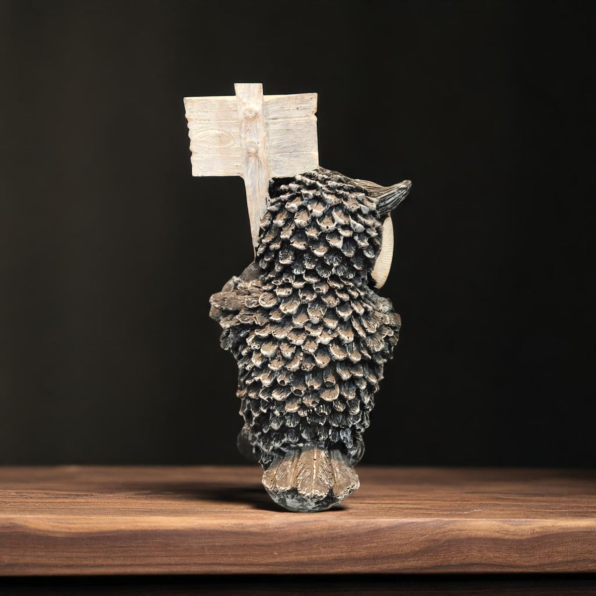 Back view of resin owl statue with carved wooden-style sign