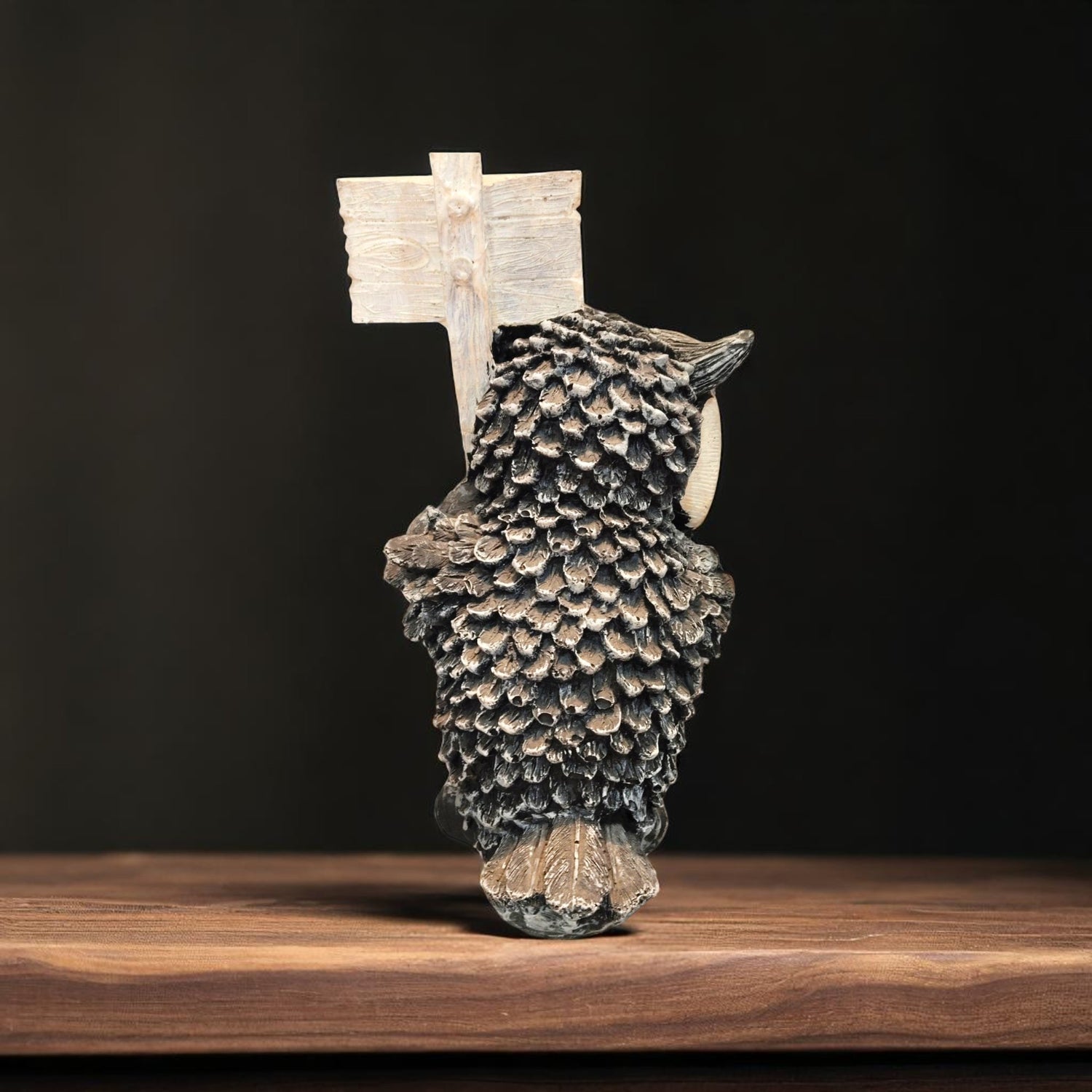 Back view of resin owl statue with carved wooden-style sign