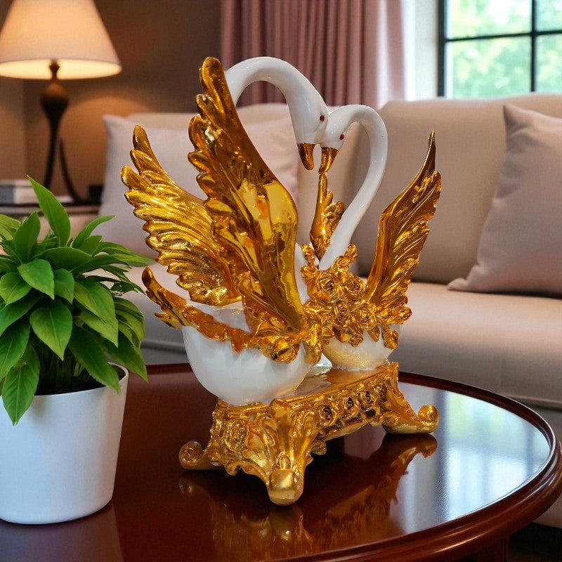 Decorative sculpture of two swans with gold wings on a table in a living room.