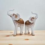 Decorative elephant figurines with intricate patterns on a wooden surface
