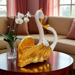 Decorative swan sculpture with gold accents on a table in a living room setting.