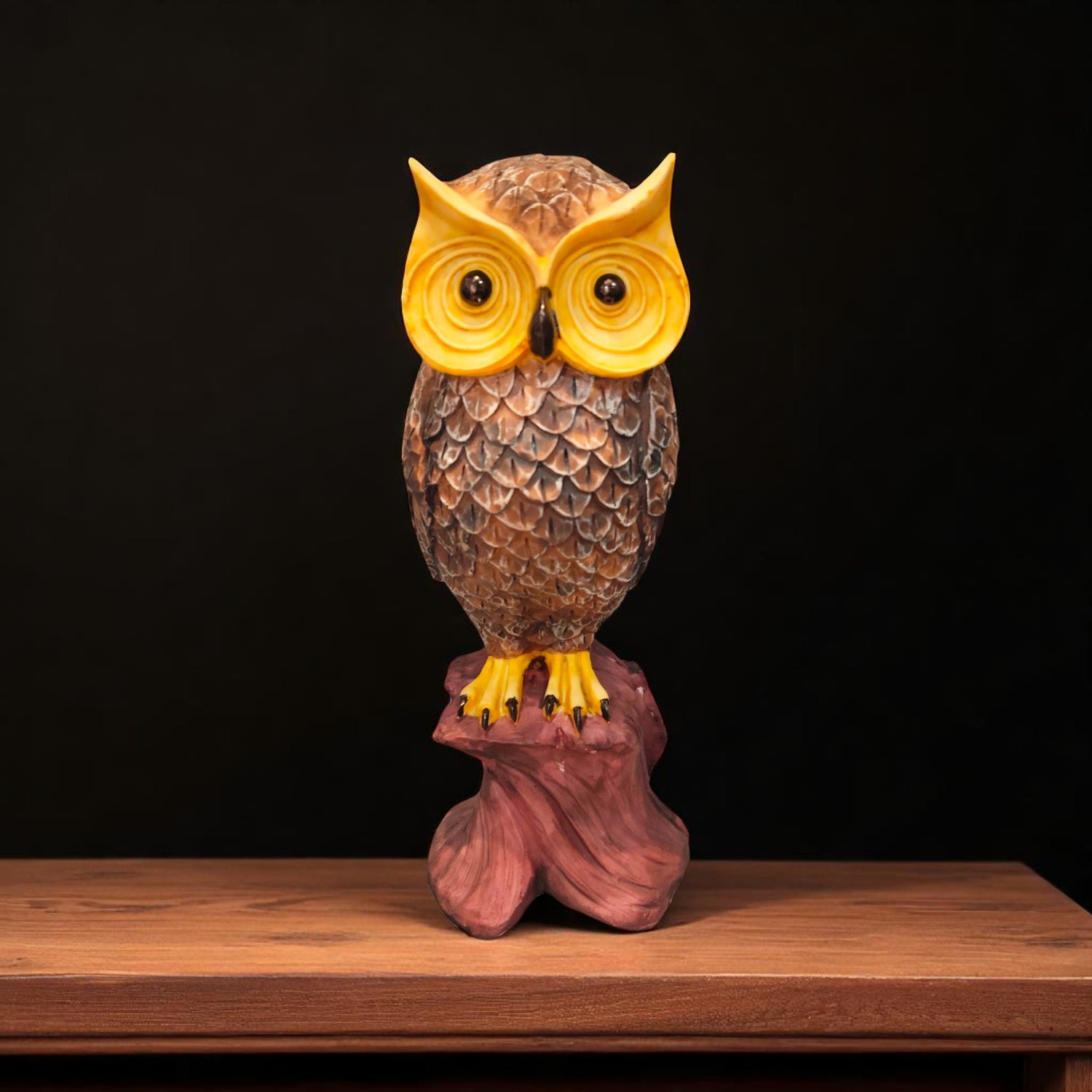 Front view of owl showpiece with yellow eyes on wooden base