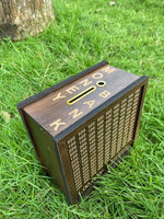 Top angled view of wooden savings bank with money slot placed on green grass background